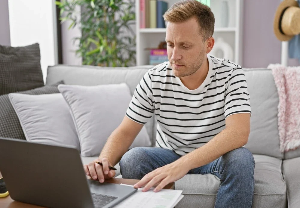 Man sitting on couch at home making an NDIS referral